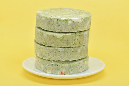 Green vegetable cutlets in plate on yellow background. Frozen veggie cutlets made from green...