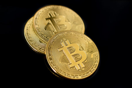 Gold Bitcoin coins on black background. Three gold bitcoin coins. Bitcoin close up. Golden bitcoins....