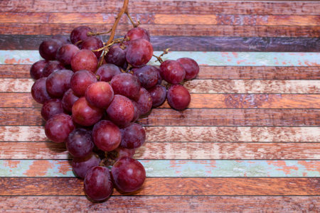 bunch of grapes on background of textured wooden table top. Concept: winemaking, fresh fruit, proper...