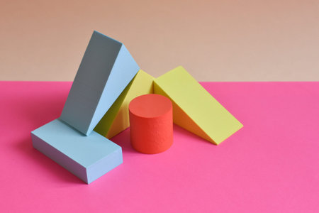 Pink and yellow abstract background with three-dimensional geometric shapes in pastel colors....