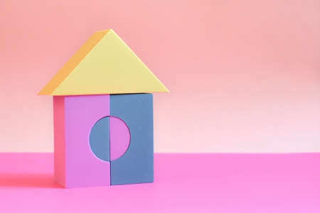 toy house built from building blocks for children on pink background. Colored cubes in shape of house. house made of building blocks. Concept: dream home, happy life, mortgage investmentの写真素材