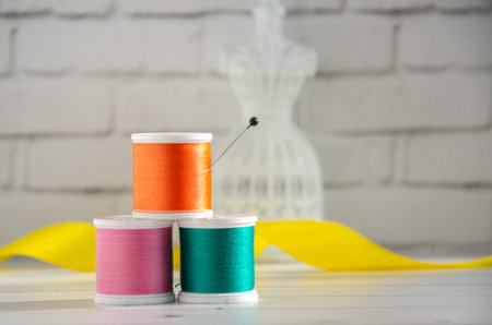 Spools of colored thread and miniature mannequin, hanger for sewing clothes. Concept: needlework,...
