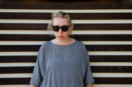 drunk woman in a tense pose with sunglasses, stern look. Tired indignant woman ready for conflictの写真素材