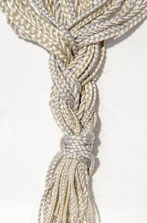 Many synthetic fiber braids with different weaves, gathered in one braid on a white background....