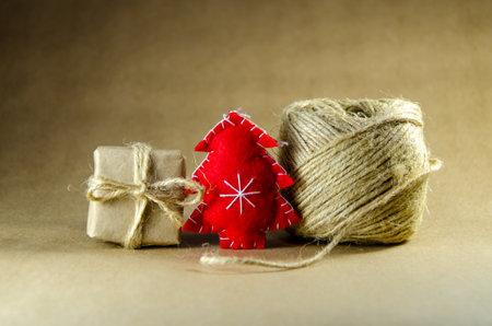 gift box in eco-friendly packaging, handmade Christmas tree made of felt and spool of jute rope. Background for Christmas and New Year. zero waste, eco friendly gift wrapping on kraft paper backgroundの写真素材