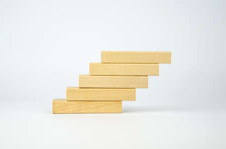 Wooden bars are stacked in the form of steps. Blank blocks of wood on top of each other. The concept of business, interaction, career growth. Template for design, space for text and symbols.の写真素材