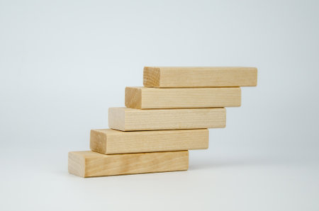 Wooden bars are stacked in the form of steps. Blank blocks of wood on top of each other. The concept of business, interaction, career growth. Template for design, space for text and symbols.の写真素材