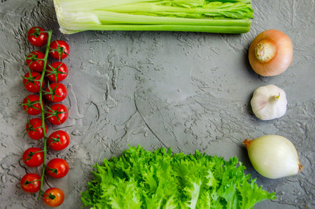 Fresh farm vegetables are laid out on a concrete tabletop. Ingredients for a vegetable dish, diet...