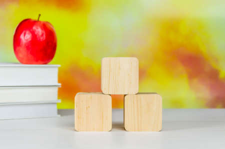 Stack of books, Red apple, colored pencils and cubes on a desktop on a blurred autumn background. back to school,の写真素材