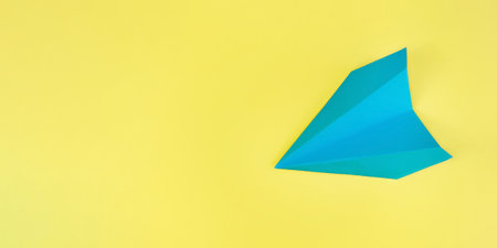 blue paper airplane on a yellow background. Mockup, design, concepts of travel, air travel, vacation, recreation. space for copying and textの写真素材