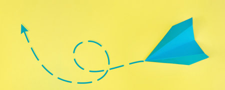 blue paper airplane on a yellow background. Mockup, design, concepts of travel, air travel, vacation, recreation. space for copying and textの写真素材
