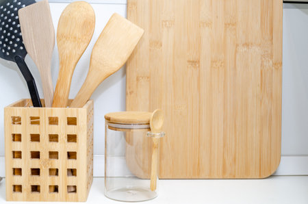 Eco friendly Bamboo kitchen utensils on kitchen table. wooden and plastic spatulas for cookingの写真素材