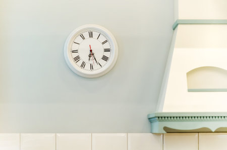 Round wall clock in kitchen interior. clock next to kitchen hood. Interior details, Provence styleの写真素材