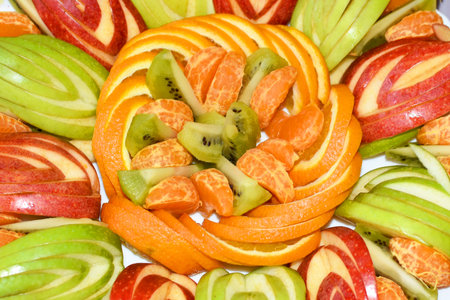 Fruit slices are beautifully laid out on a plate close-up.の写真素材