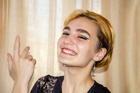 Portrait of a laughing cute young blonde woman with short hair. happy young woman with short blond hair and bright eye makeupの写真素材