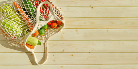 string bag with fresh vegetables. Fresh farm vegetables in mesh bag on wooden background. rusticの写真素材