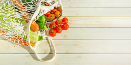 string bag with fresh vegetables. Fresh farm vegetables in mesh bag on wooden background. rusticの写真素材