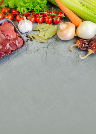 Raw chicken liver, vegetables and spices for making pate on a textured concrete-gray background.の写真素材