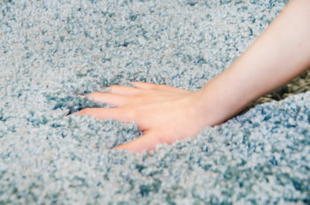 woman chooses carpet. Hand touches soft carpet in a store, close-upの写真素材