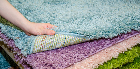 woman chooses carpet. Hand touches soft carpet in a store, close-upの写真素材