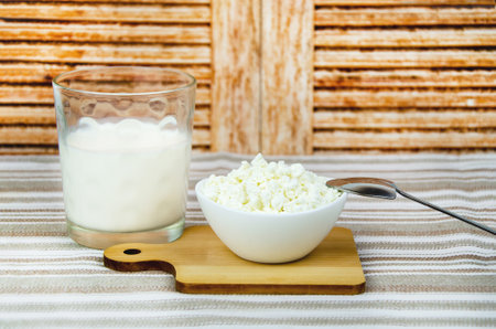 glass of milk, a cup of fresh cottage cheese. Fresh farm dairy products, simple rustic still lifeの写真素材