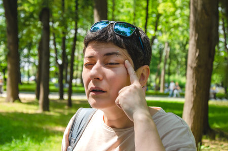 A woman walking in the park without glasses, attentively looks into the distance, squints her eyes...