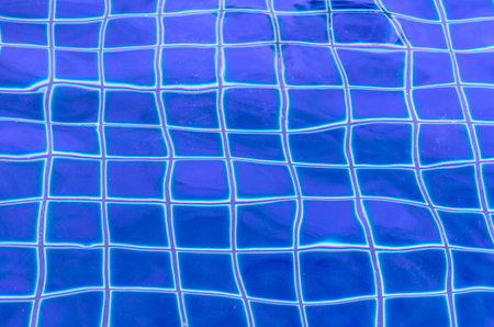 Abstract texture, background of blue swimming pool with transparent rippled water