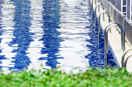 Swimming pool with ladder in front of hotel room. Swimming pool at the hotel. many of the stairs to...