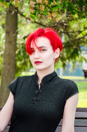 Portrait of a beautiful red-haired woman. attractive Young woman with pink hair in a strict black...