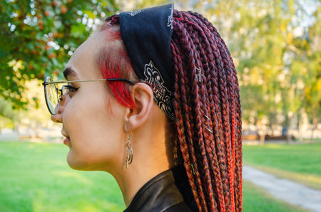 Close-up of the head of a young woman with many of thin African braids, gathered into a hairstyle with a bandana. informal modern styleの写真素材