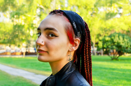 Portrait of a cute young woman with many of long black and red African pigtails, gathered into a hairstyle with a bandana. informal modern styleの写真素材