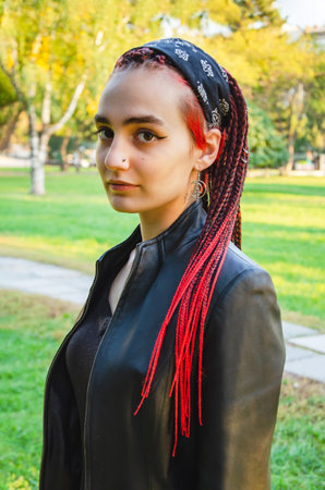 Portrait of a cute young woman with many of long black and red African pigtails, gathered into a hairstyle with a bandana. informal modern styleの写真素材