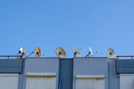 Row of Satellite Dishes on a Building Rooftopの写真素材