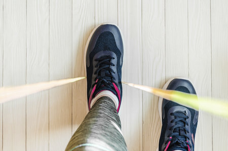 woman jumps rope. top view of female legs in sports sneakers stepping on jump ropeの写真素材