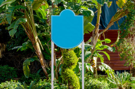 Blue empty billboard on city street surrounded by trees.の写真素材