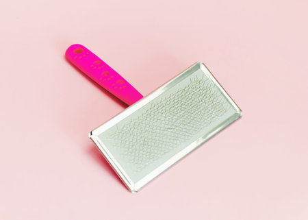 pink animal hair cleaning comb on pink background. Grooming tool for dogs and cats.
