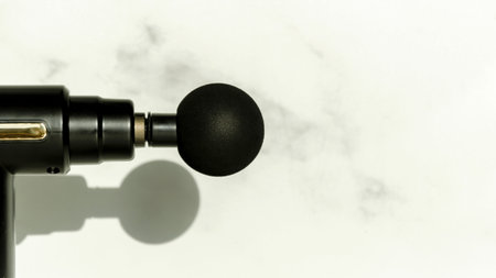 Close-up of round nozzle of a massage gun on a white background. Banner, space for textの写真素材