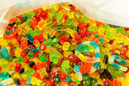 Assortment of delicious colorful gummy bear-shaped chewy candies. Top view. Close-up of colorful...