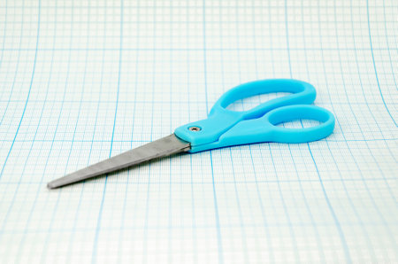 stationery scissors for paper on notebook sheet in cageの写真素材