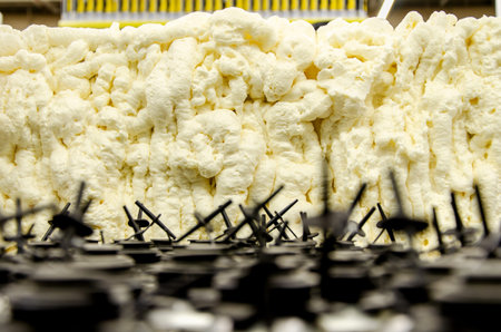 Expanding foam fills a space, with mechanical components in the foreground. The foam appears dense...