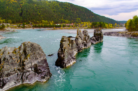 Scenic view of a winding river flowing through jagged rock formations against a lush green mountain...