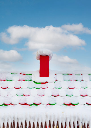 Colorful Snow-Covered Roof with Red Chimneyの写真素材