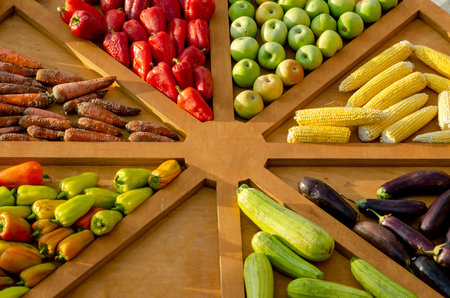 An assortment of fresh fruits and vegetables displayed in a wooden market display.