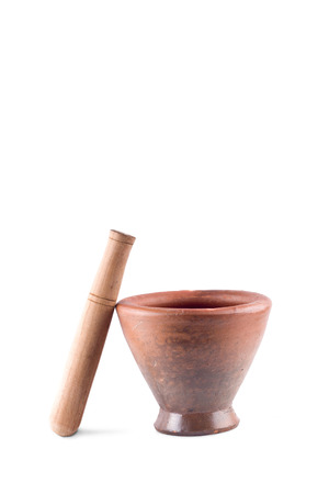 Clay mortar and wood pestle is used to mix the ingredients on white background  cooking kitchenware object isolatedの写真素材