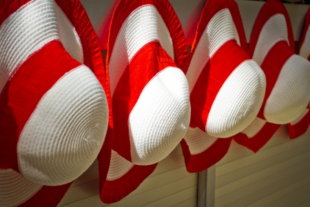 Red woman's hats naging on the wall outside e shopの写真素材