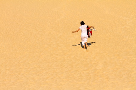 Woman running down the duneの写真素材