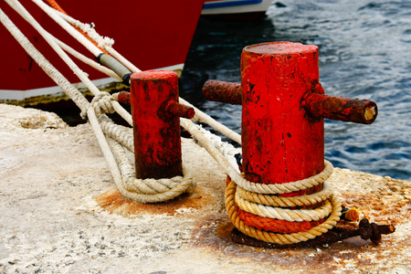 Pier with rusty bollard and mooring ropeの写真素材