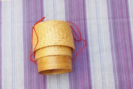 Kratip thai bamboo sticky rice container on loincloth fabric backgroundの写真素材