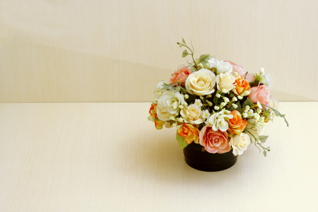 Artificial flowers in flowerpot on wooded background.の写真素材