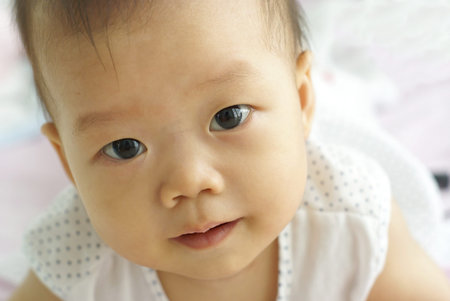Cute baby looking for something, In front of her. Face of cute Asian infant looking to someone.